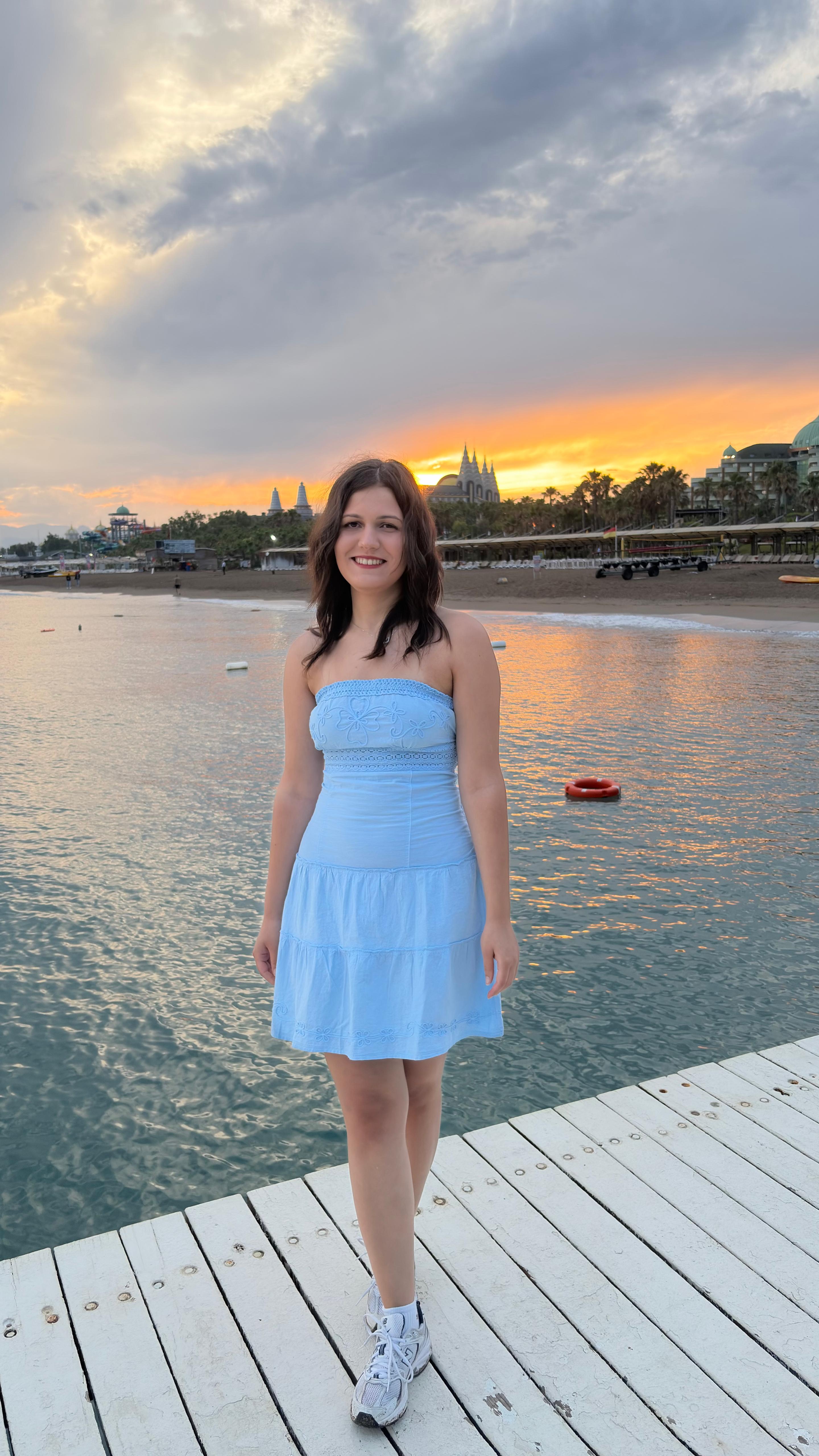 Asya on the pier in a light blue top at sunset in Turkey