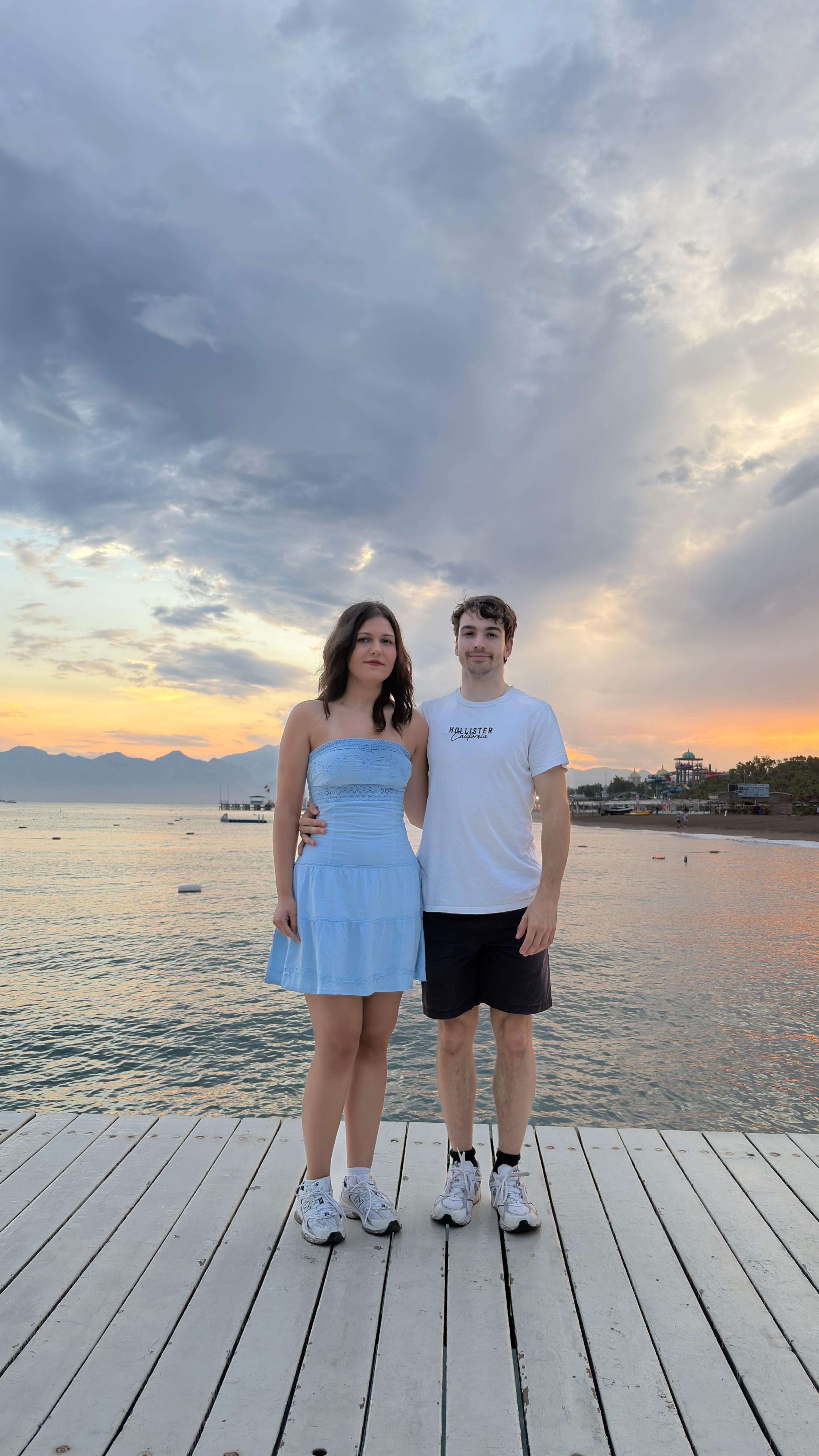 Asya and Jan on a wooden pier as the sun goes down